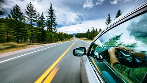 electric vehicle driving down a mountain road