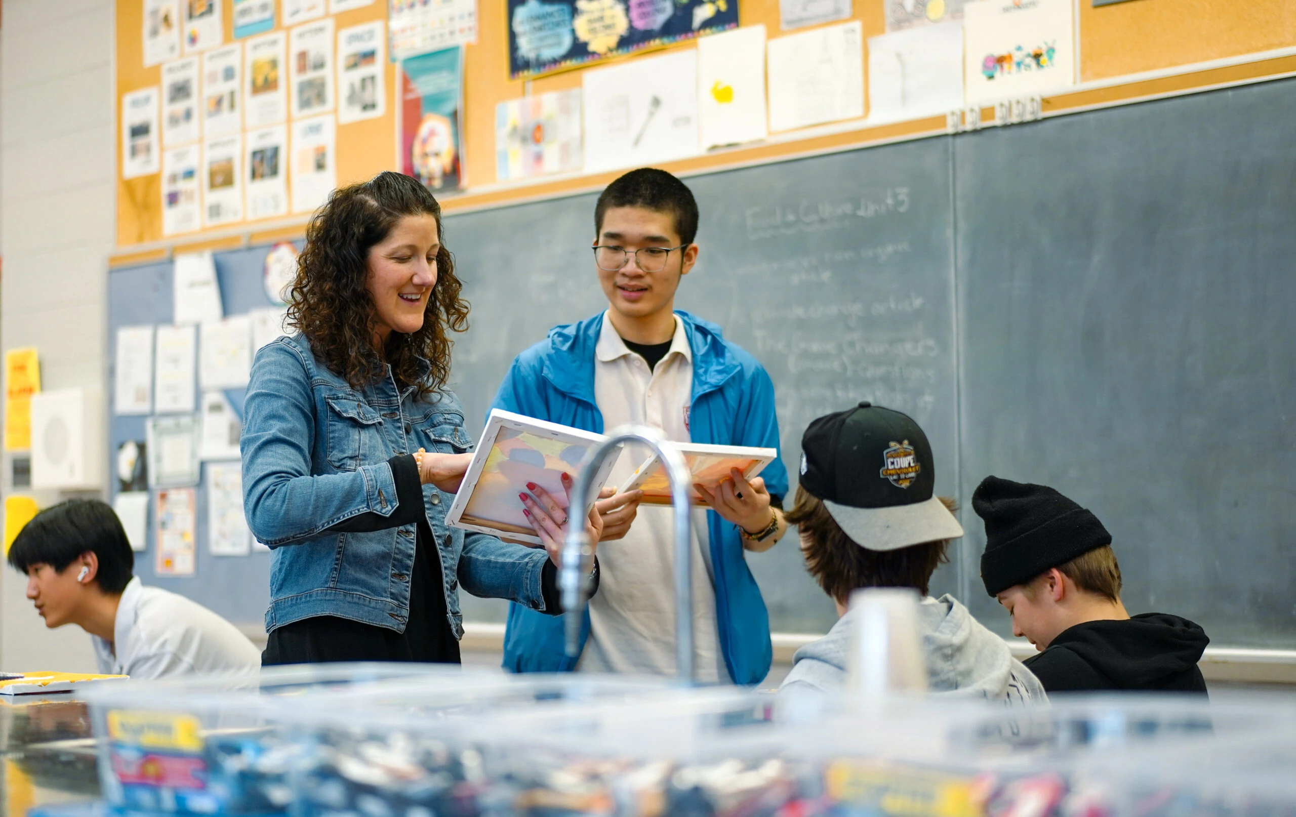 Teacher helping students with a book in class