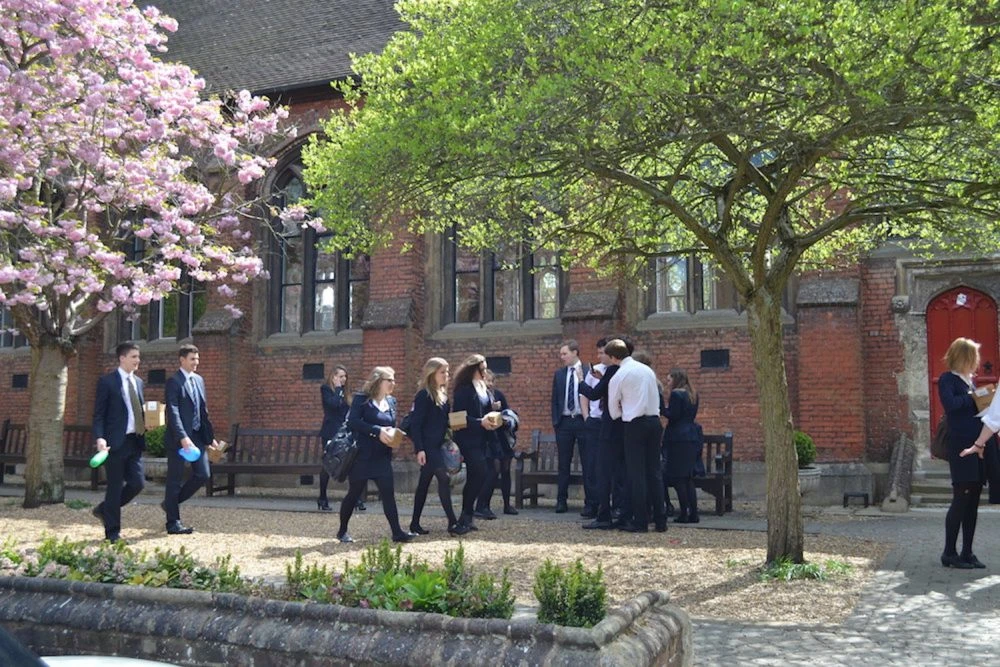 Sixth form students walking through the Berkhamsted School campus
