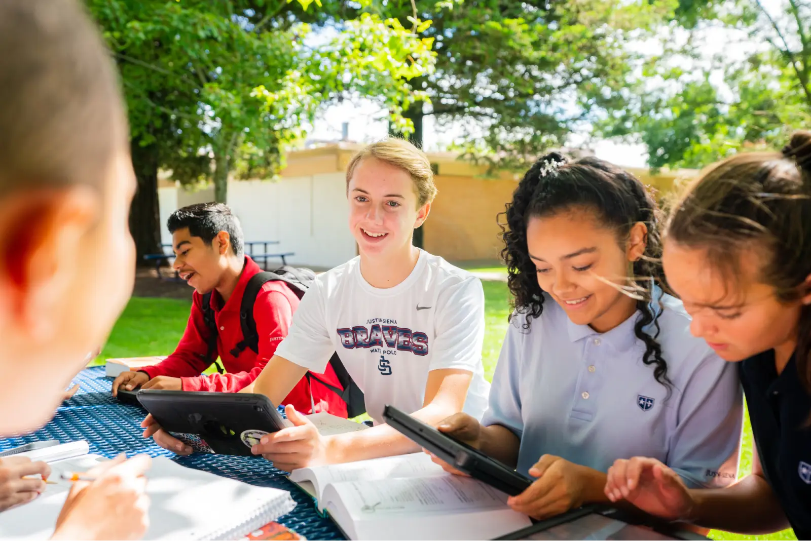 Justin-Siena High School students working together on tablets outdoors