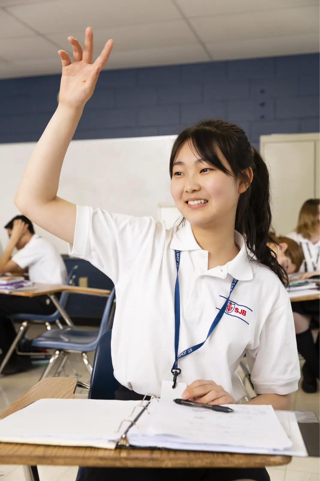 Saint John's High School student raising her hand in class