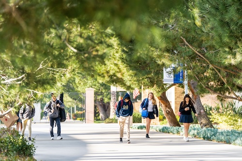 Mater Dei Catholic students walking through the tree-lined campus