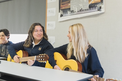 Mater Dei Catholic students playing guitar in music class