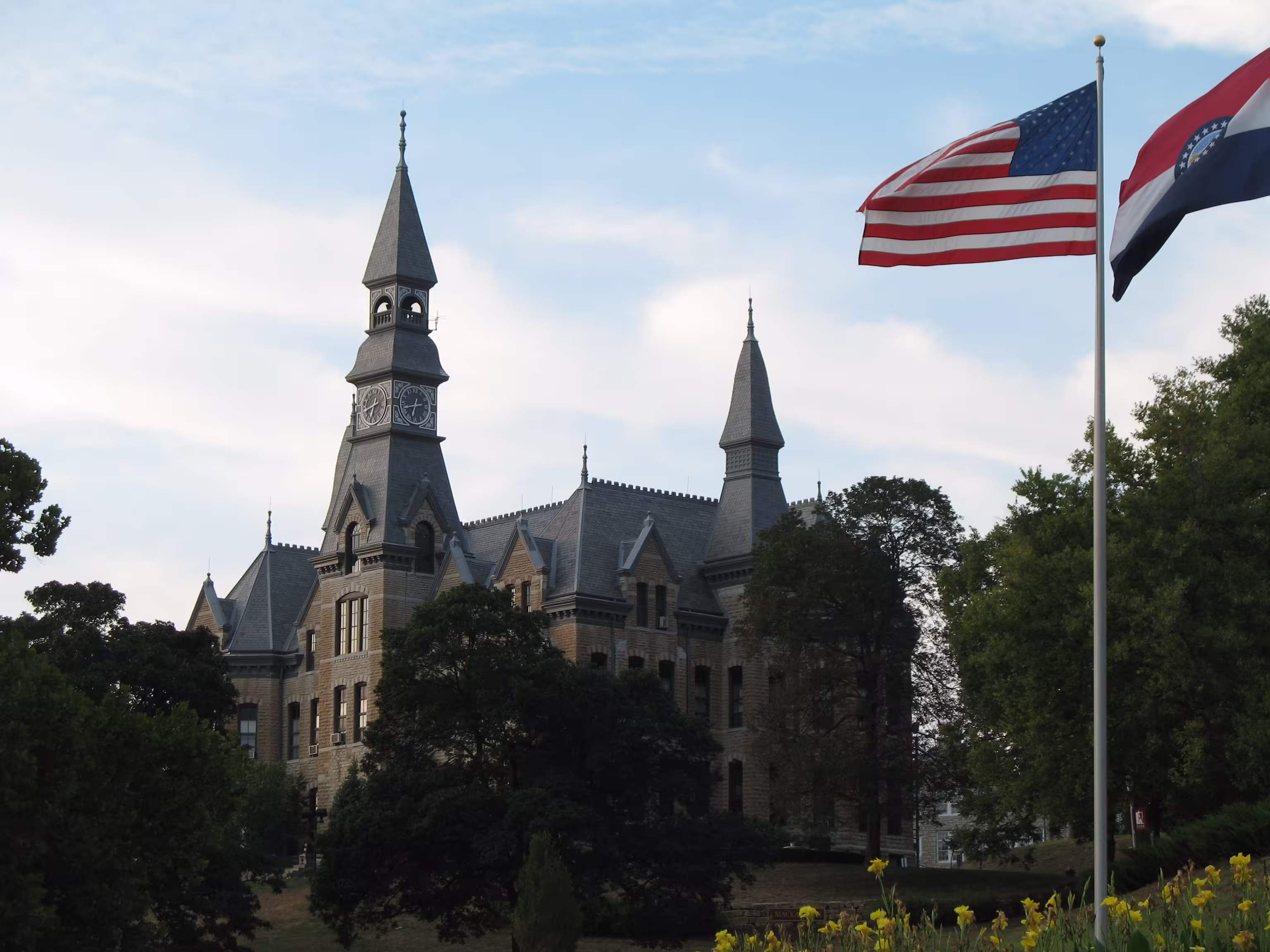 Low angle of Mckay Hall building at Parkville University with American flag