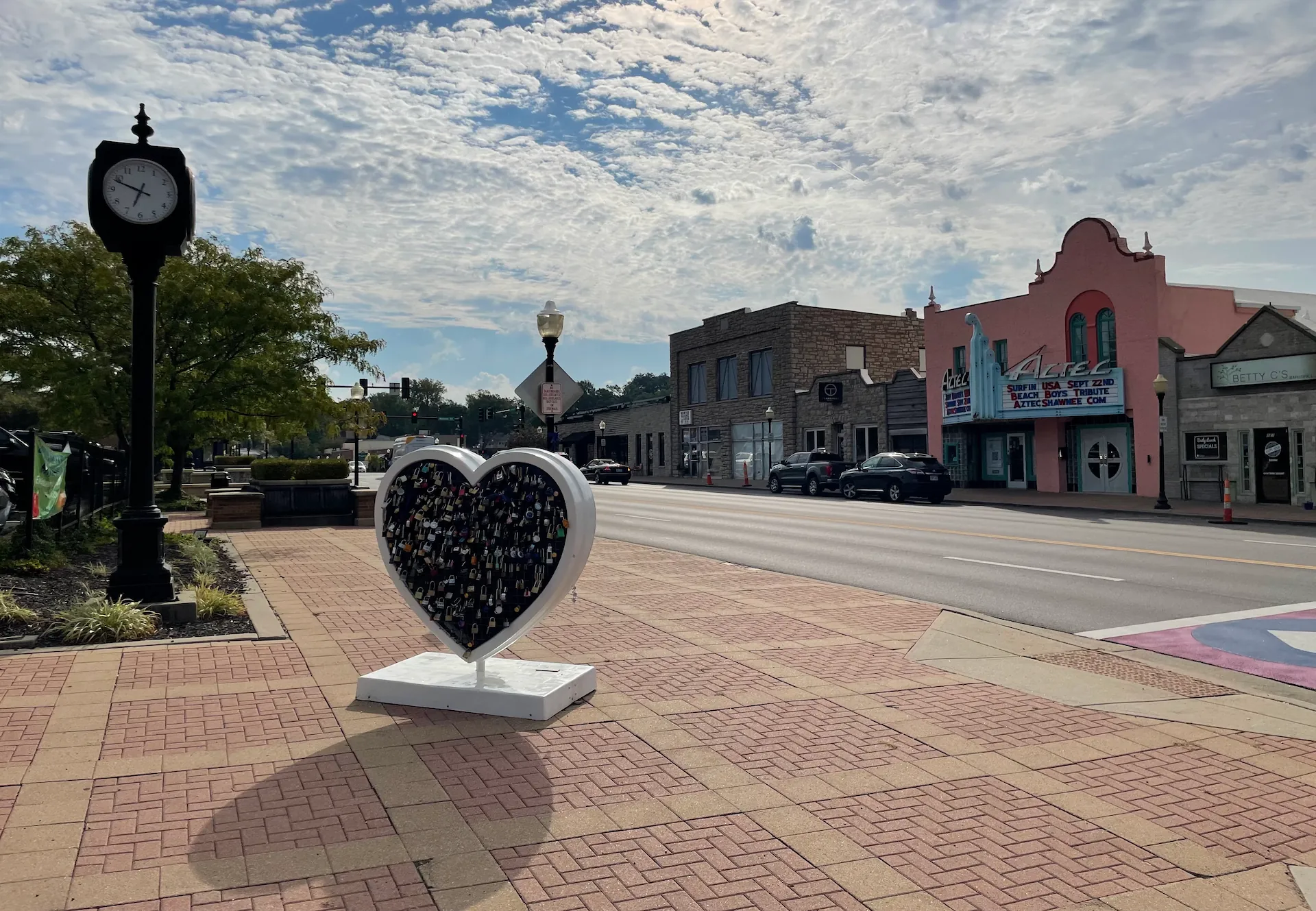 Downtown Shawnee, KS road and heart statue with adorning locks.
