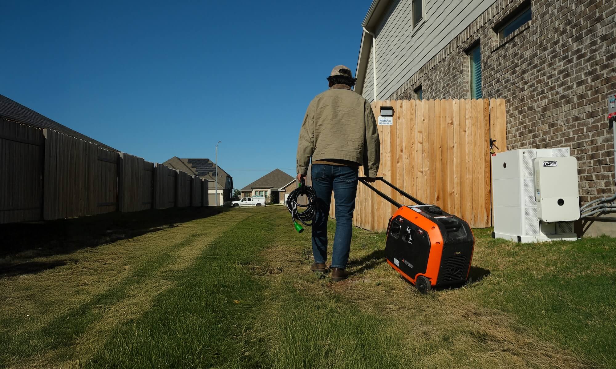 Man pulling generator on grass