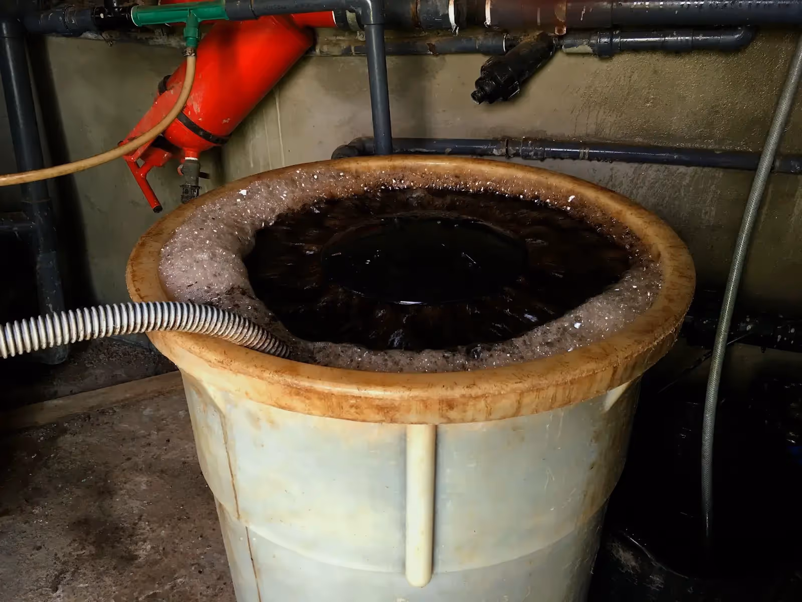 A grower making compost tea in a large container.