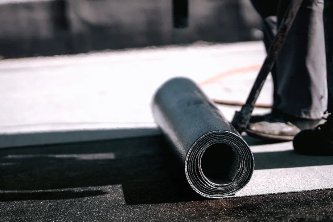 Close-up shot of a man applying bitumen waterproofing