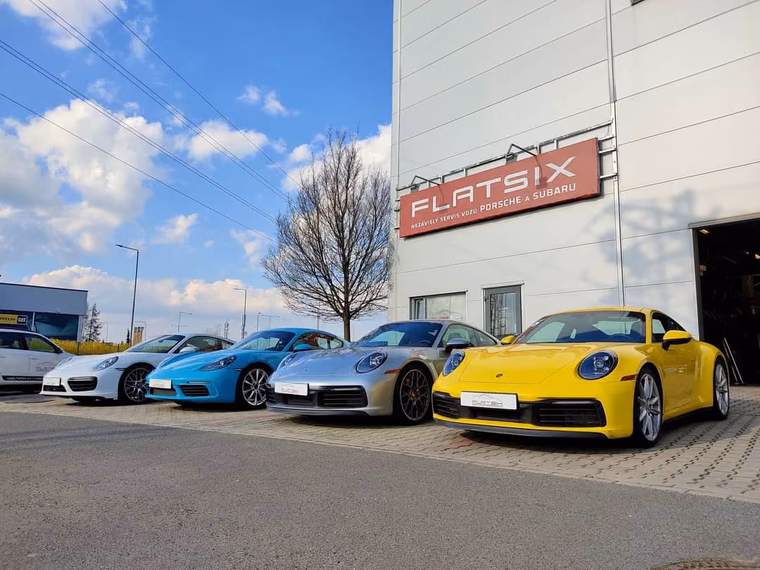 Budova servisu Flat Six se zaparkovanými vozy Porsche