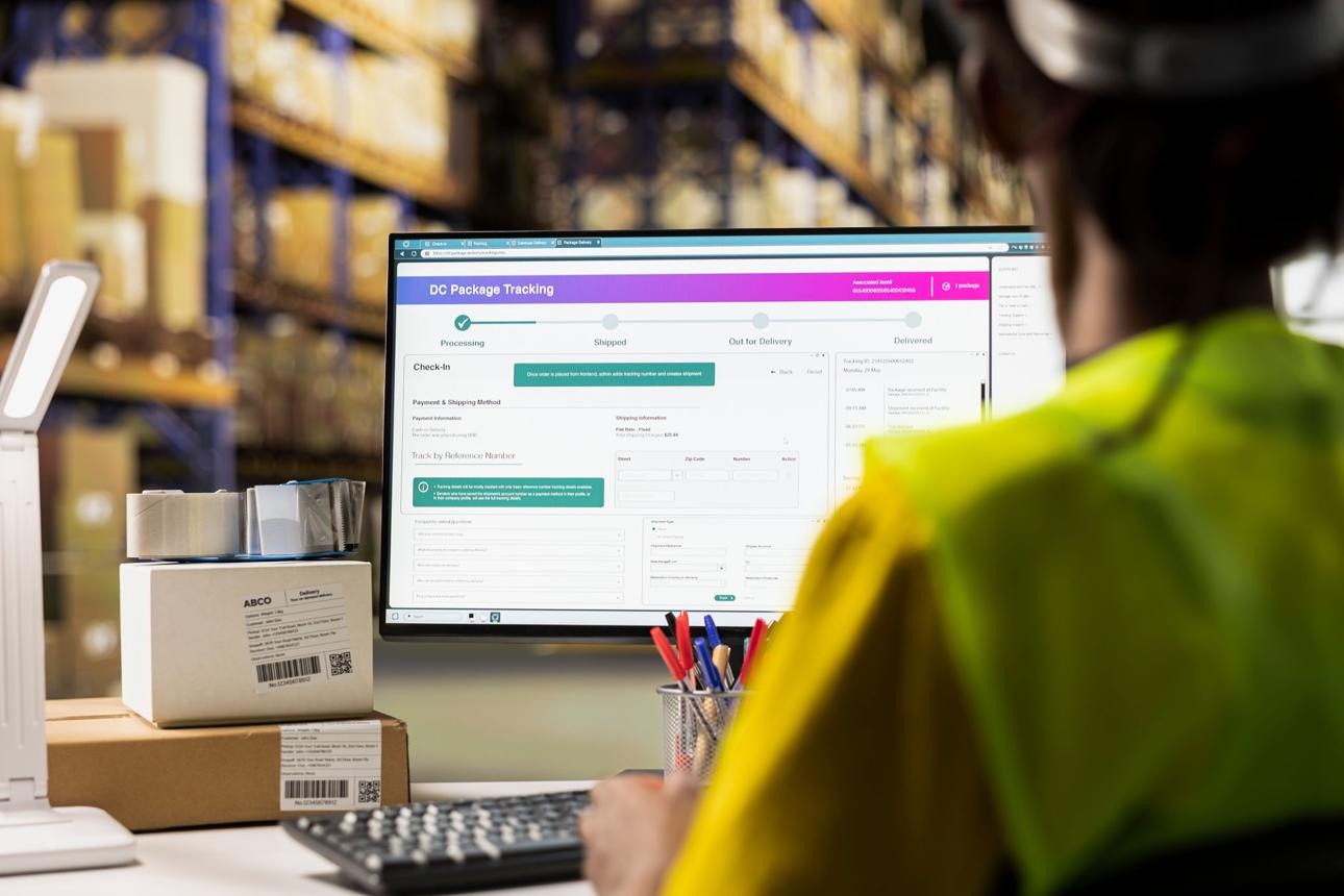 Fulfillment center black employee reviewing digital shipment status