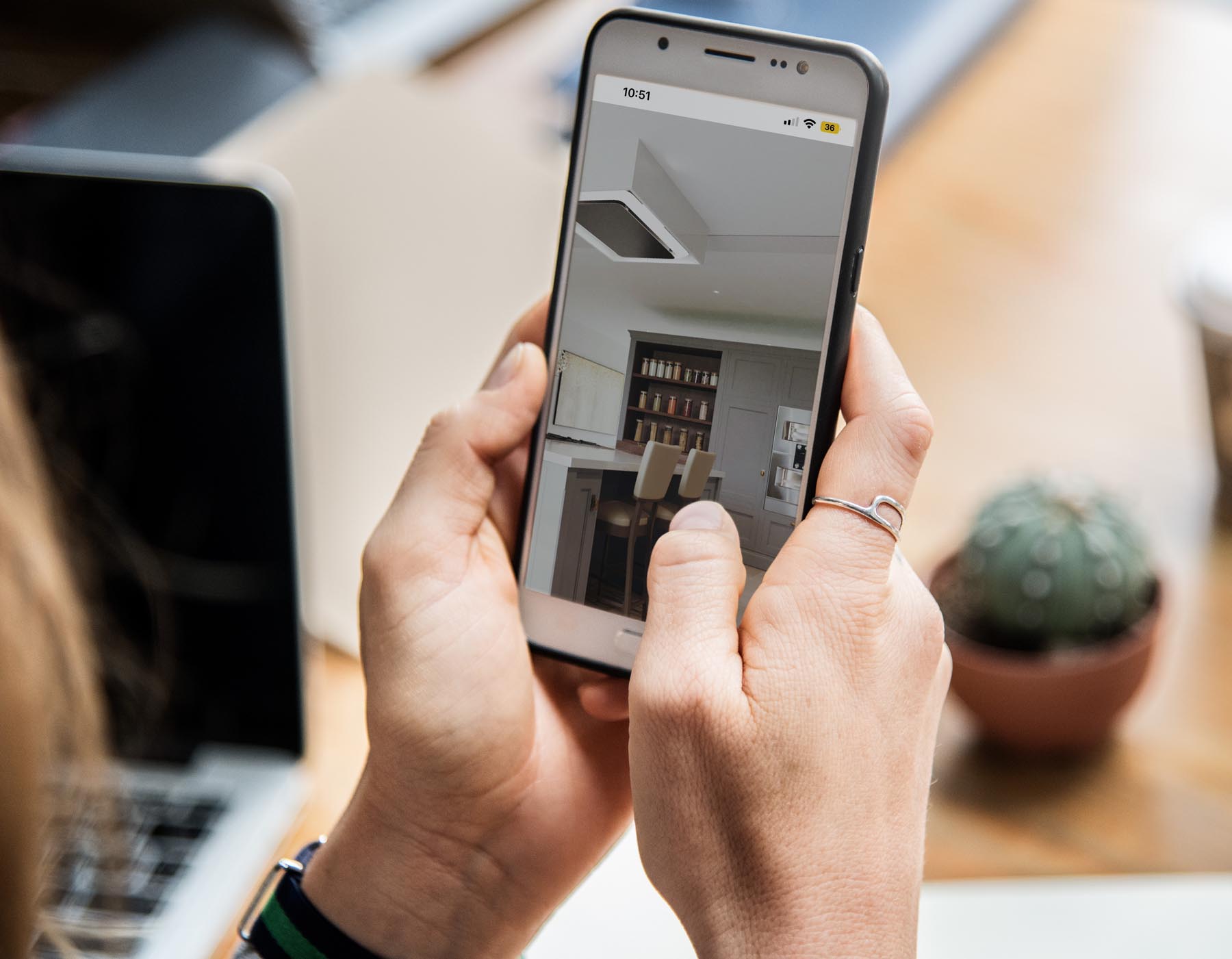 A female holding phone and browsing images of a CGI renders of the house interior
