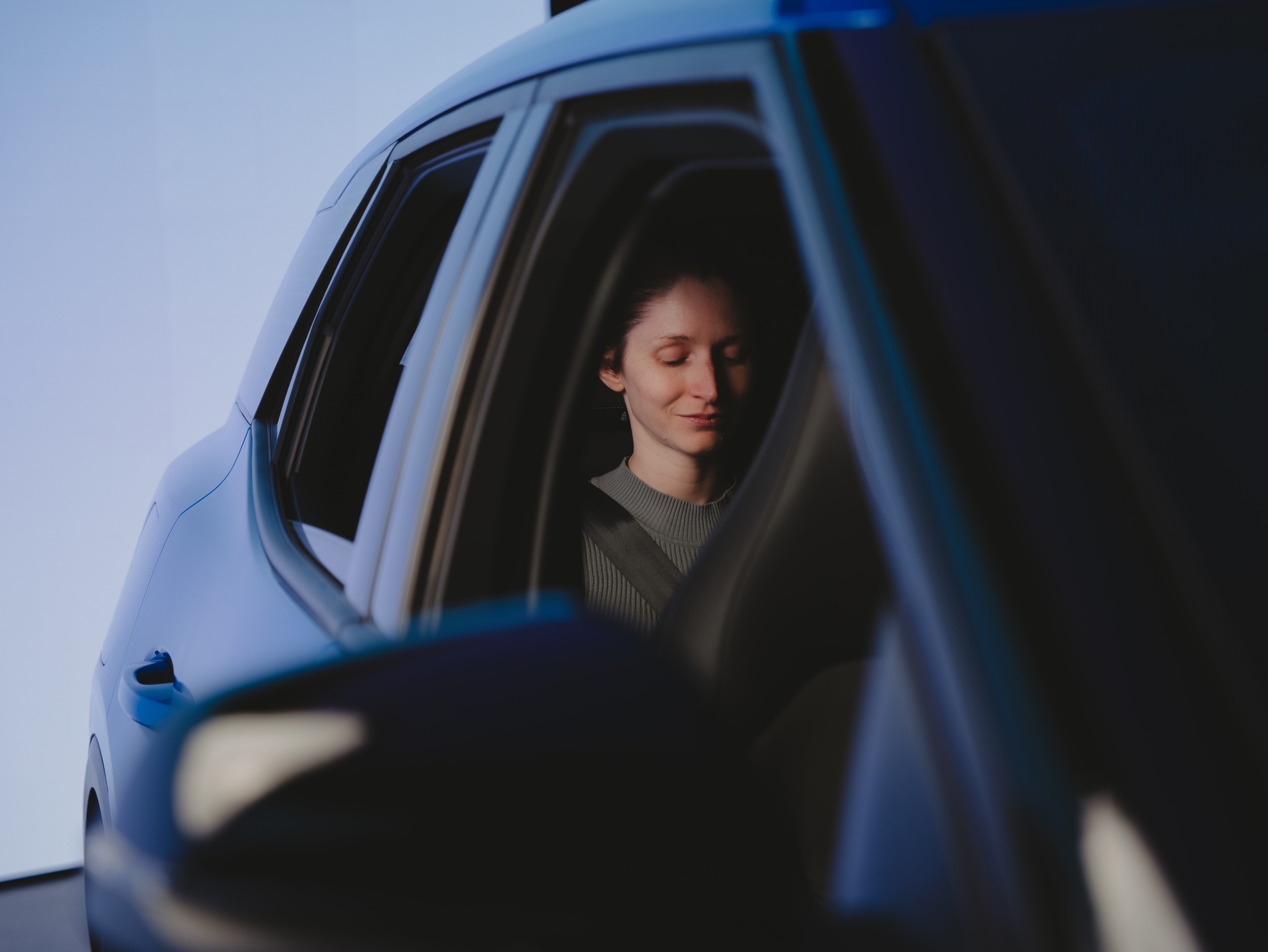 A video crew member sat in the back seat of a car in a studio