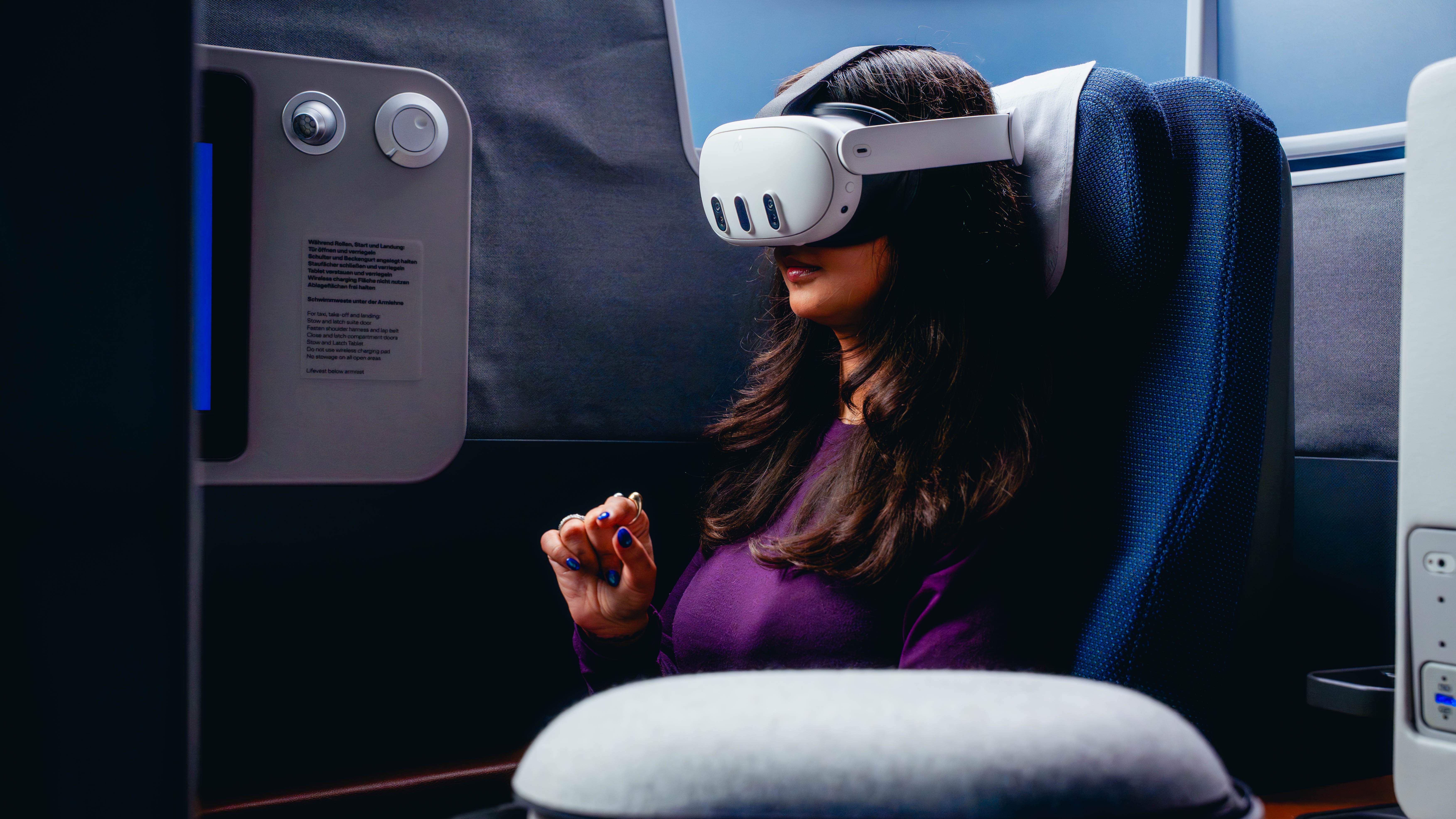 A person sat in an aircraft seat wearing a virtual reality headset
