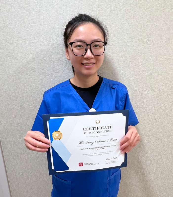registered nurse, Anna Fong, holding up her Staff Spotlight certificate
