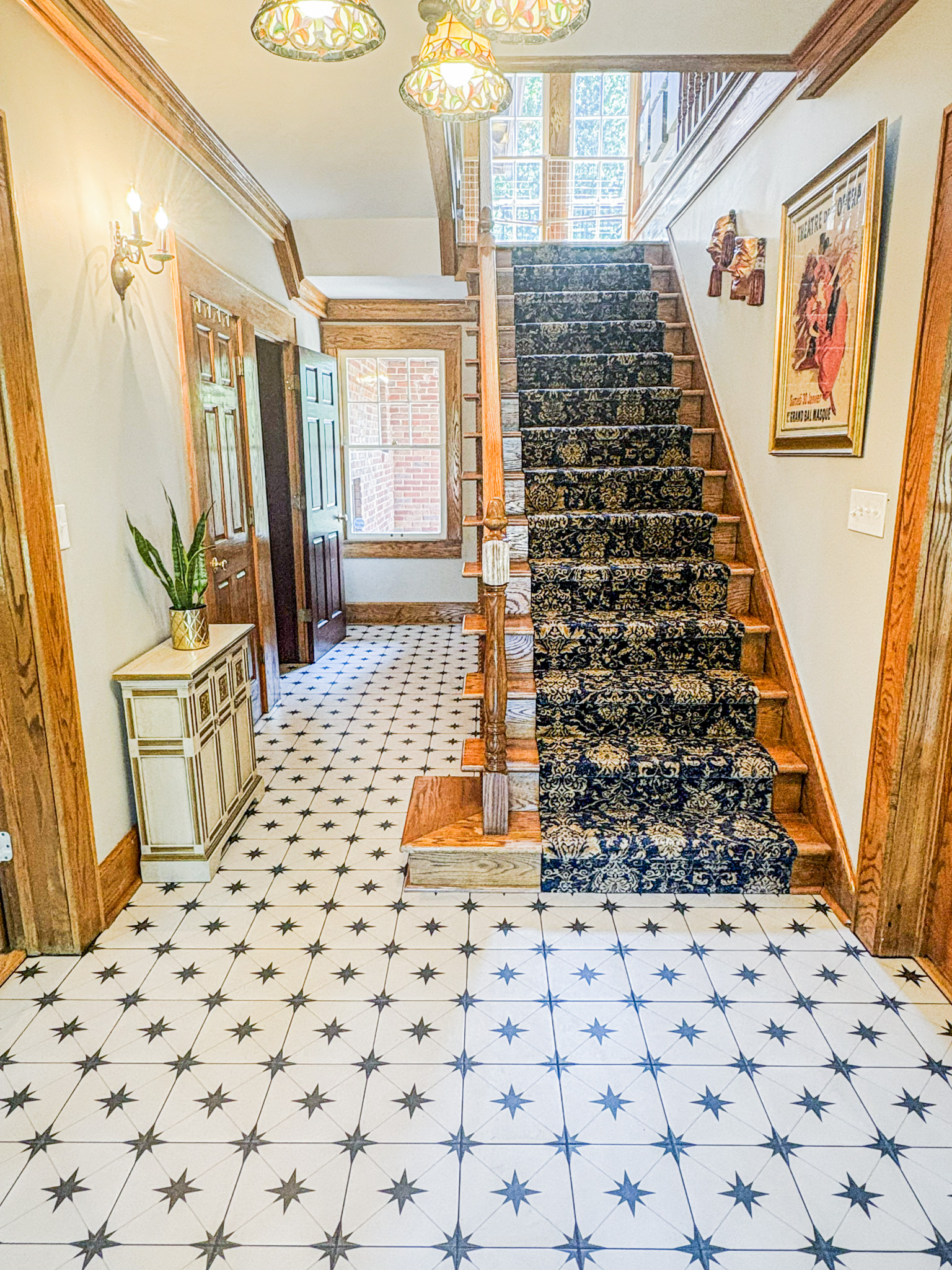 Historic entryway remodel with decorative high-end tile and charming wood trim and stairs