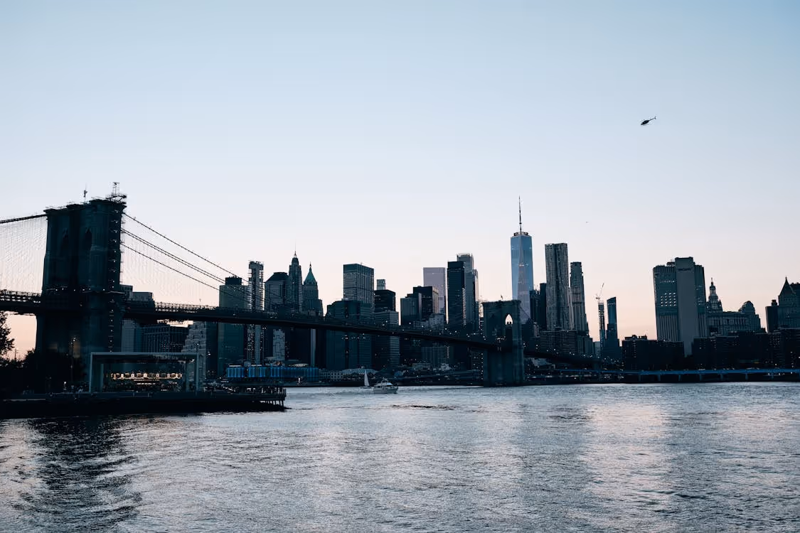 helicopter flying toward the Brooklyn Bridge in New York