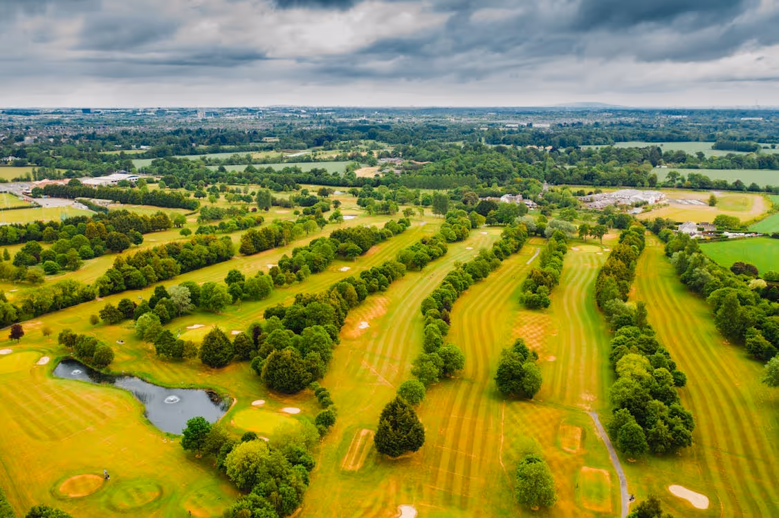 aerial view from a helicopter of lush green farmland and trees