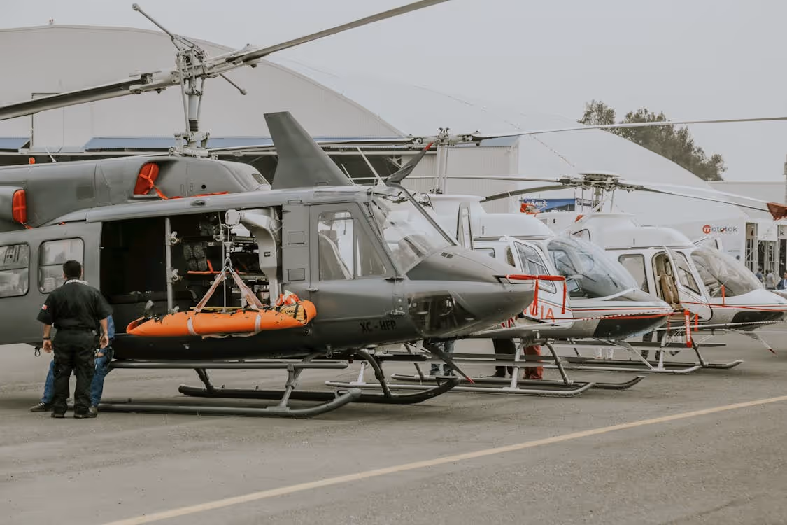 gray and white disaster response helicopters resting on a tarmac between missions