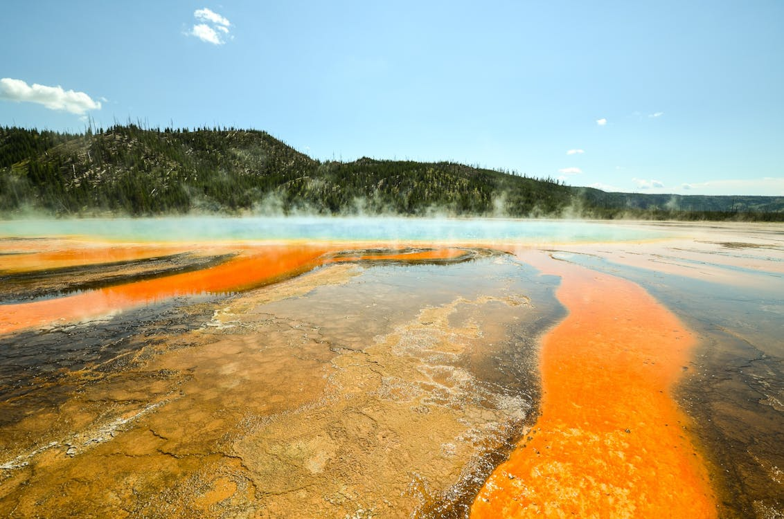 hot springs surrounded by mountains under blue skies