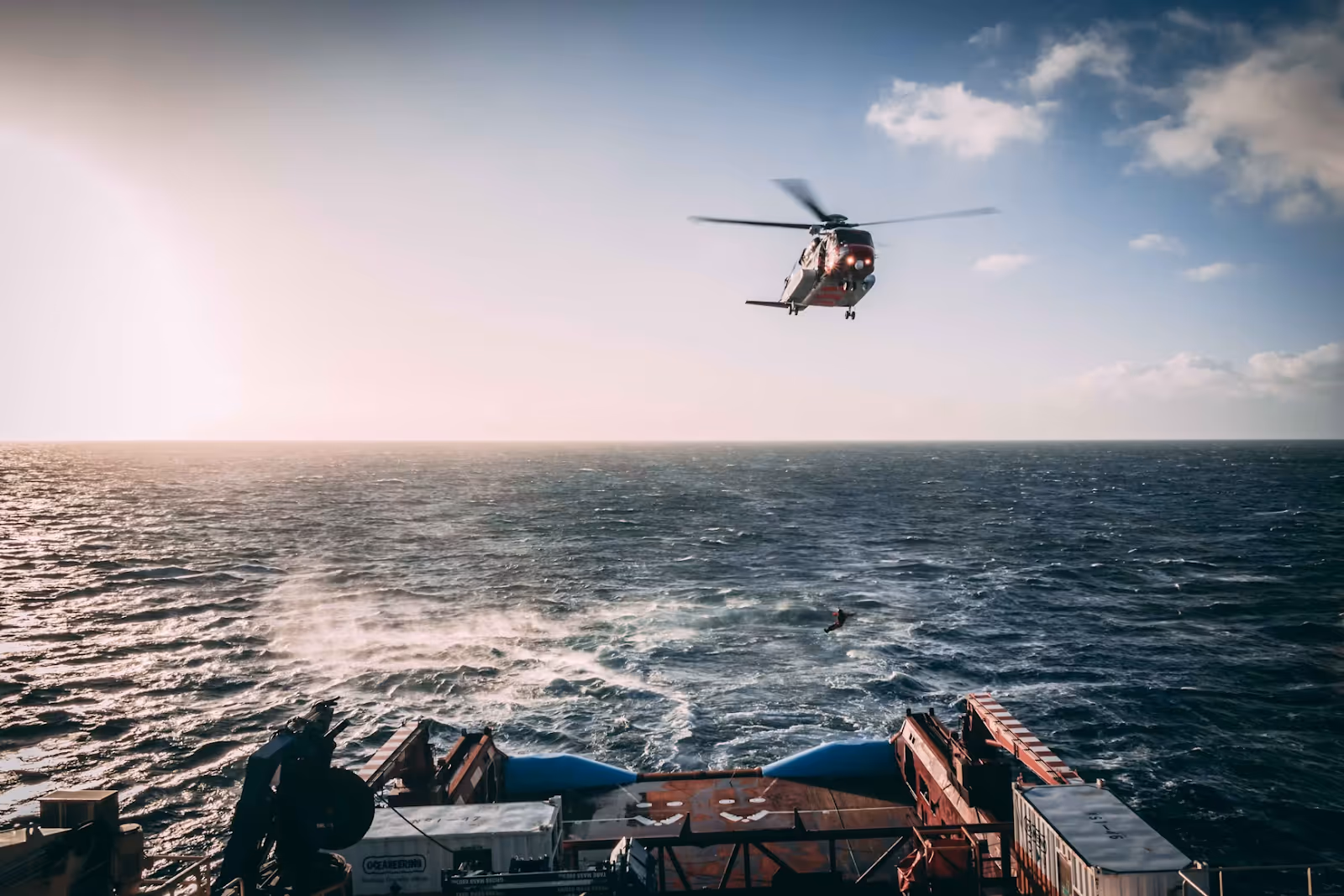 Coast Guard search and rescue helicopter flying toward a ship on the open sea