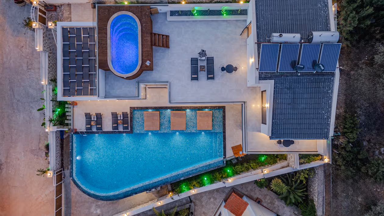 aerial view of a luxury home with a hot tub, pool, and solar panels