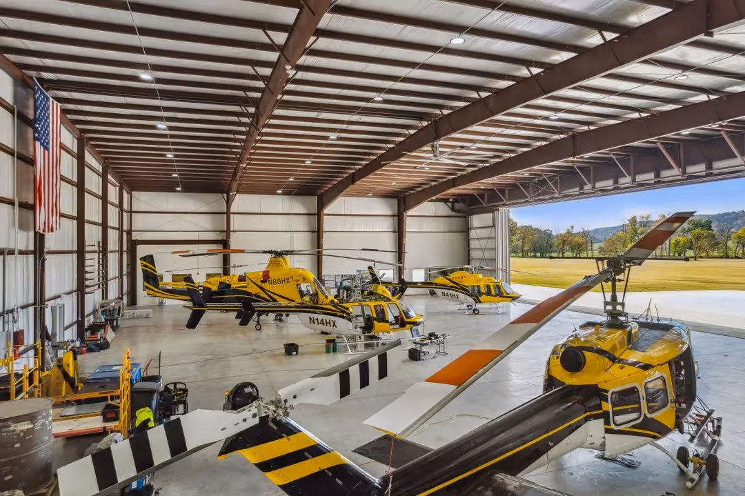 yellow, black, and white helicopters resting in Helicopter Express' North Georgia hangar