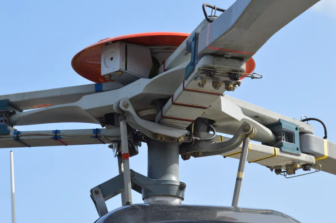 close up of a white and red helicopter rotor flying in blue skies