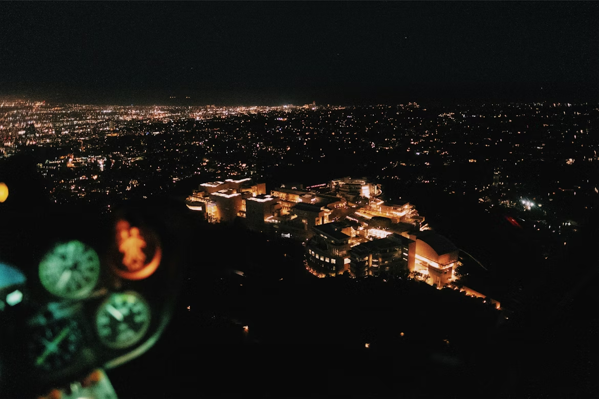 aerial view of a city at night from inside a helicopter cockpit