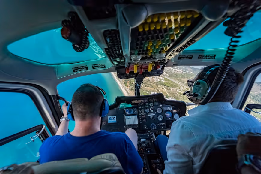 helicopter pilot and passenger flying over the ocean