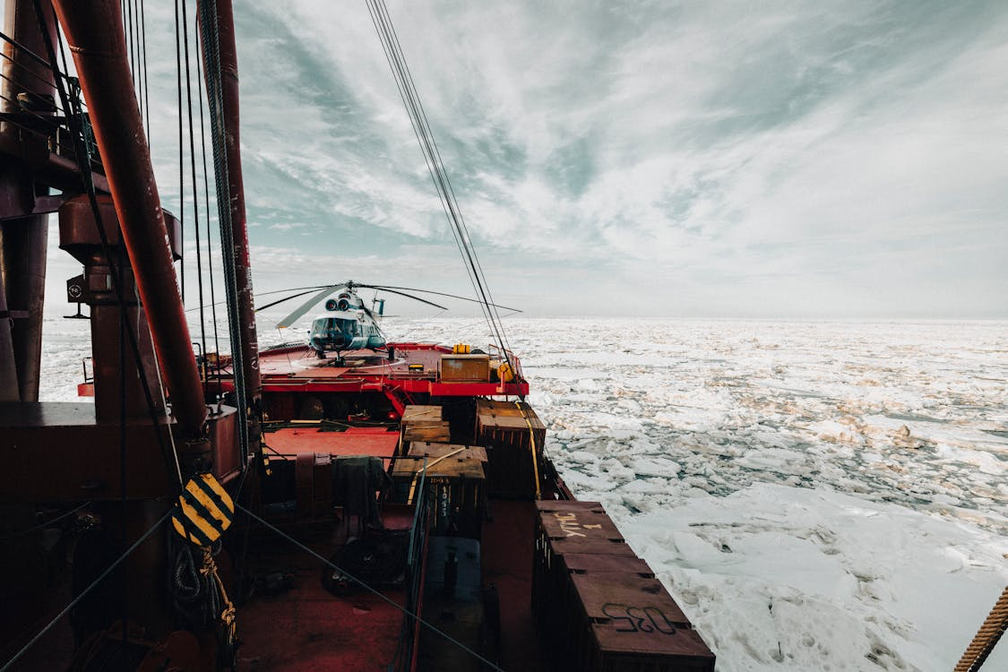 white helicopter resting on an icebreaker in the ice-covered Arctic Ocean