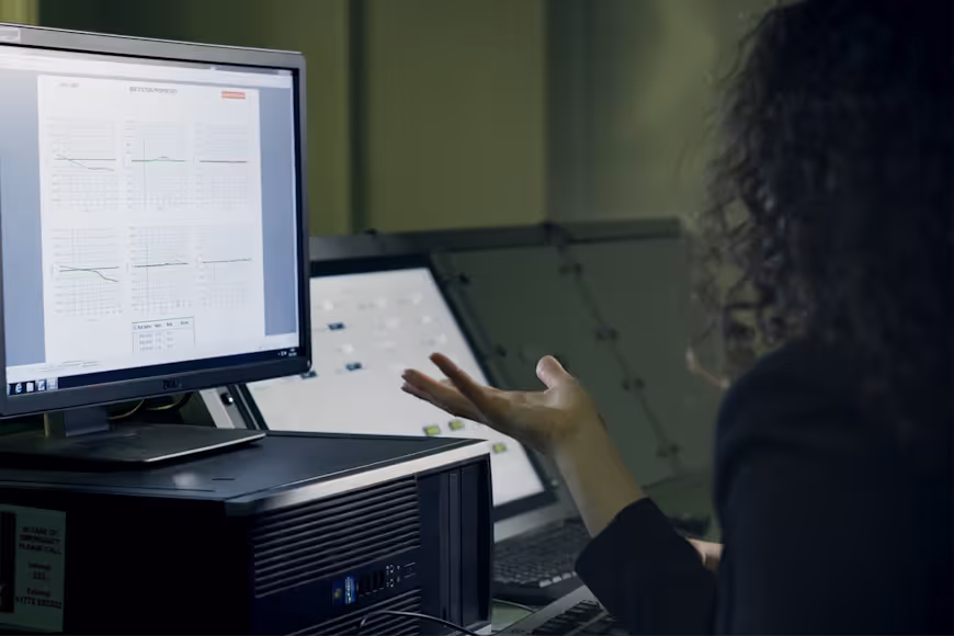 female aerospace engineer examining flight data on multiple screens