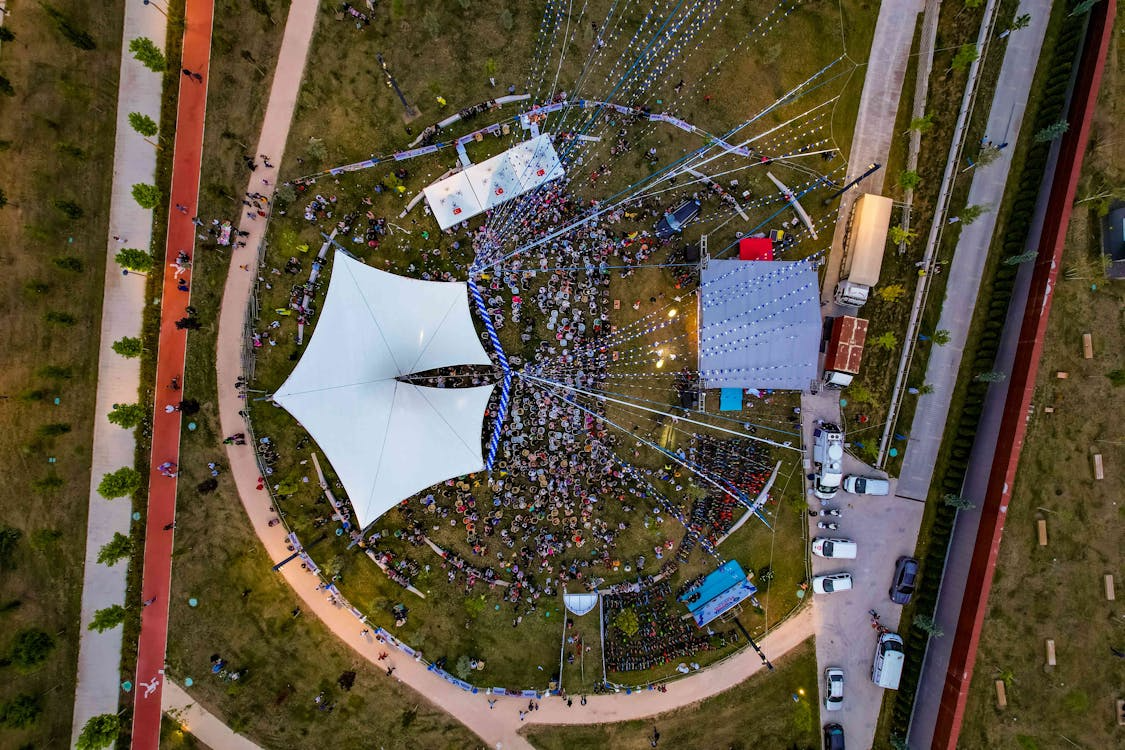 aerial view of a vibrant outdoor festival with a large crowd and stage