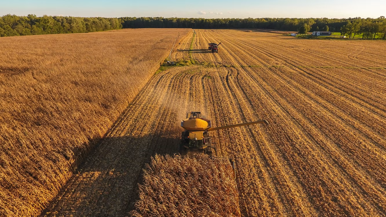 low aerial view of a tractor plowing a large field