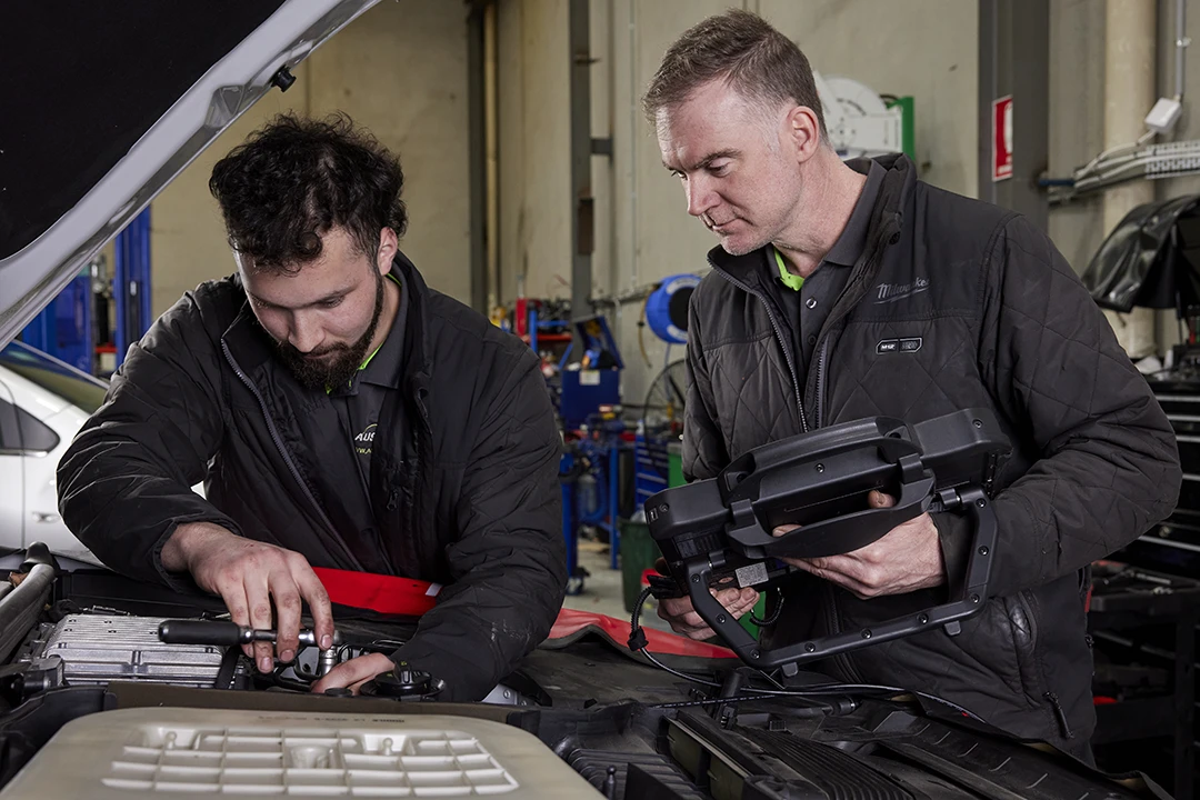 Aussie Tune’s workshop in Dandenong, Melbourne, with a Volkswagen up on a hoist for a full manufacturer-recommended logbook service.