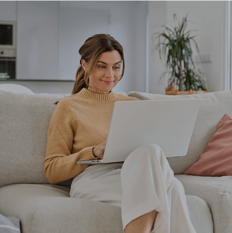 A woman using a laptop on her couch