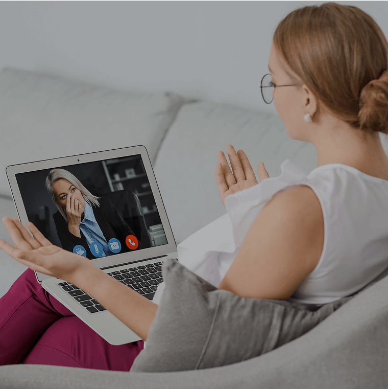A woman on a video consultation with a doctor from her couch