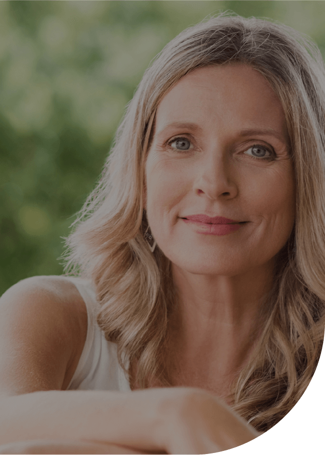 A smiling woman in her late forties, outdoors