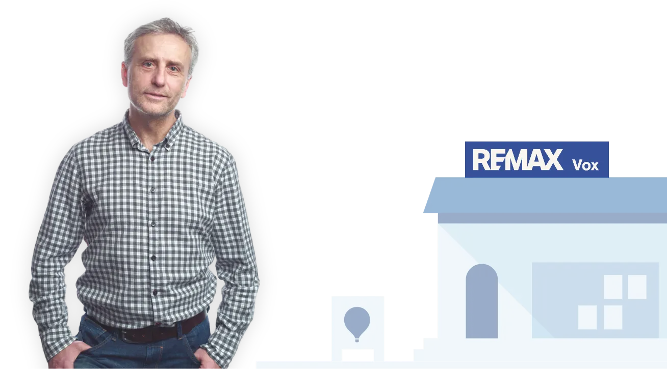 Muž v kostkované košili stojící vedle stylizovaného domu s nápisem RE/MAX.