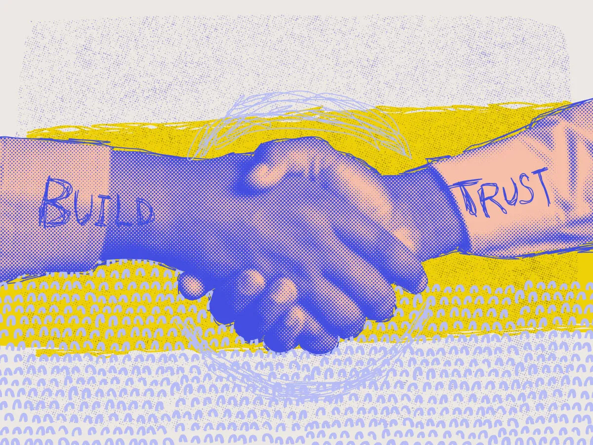 two hands shaking, with the words build trust written over them