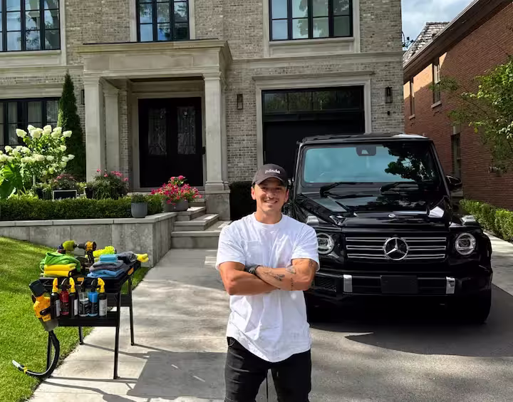 A Panda Hub detailer standing in front of a freshly detailed black SUV