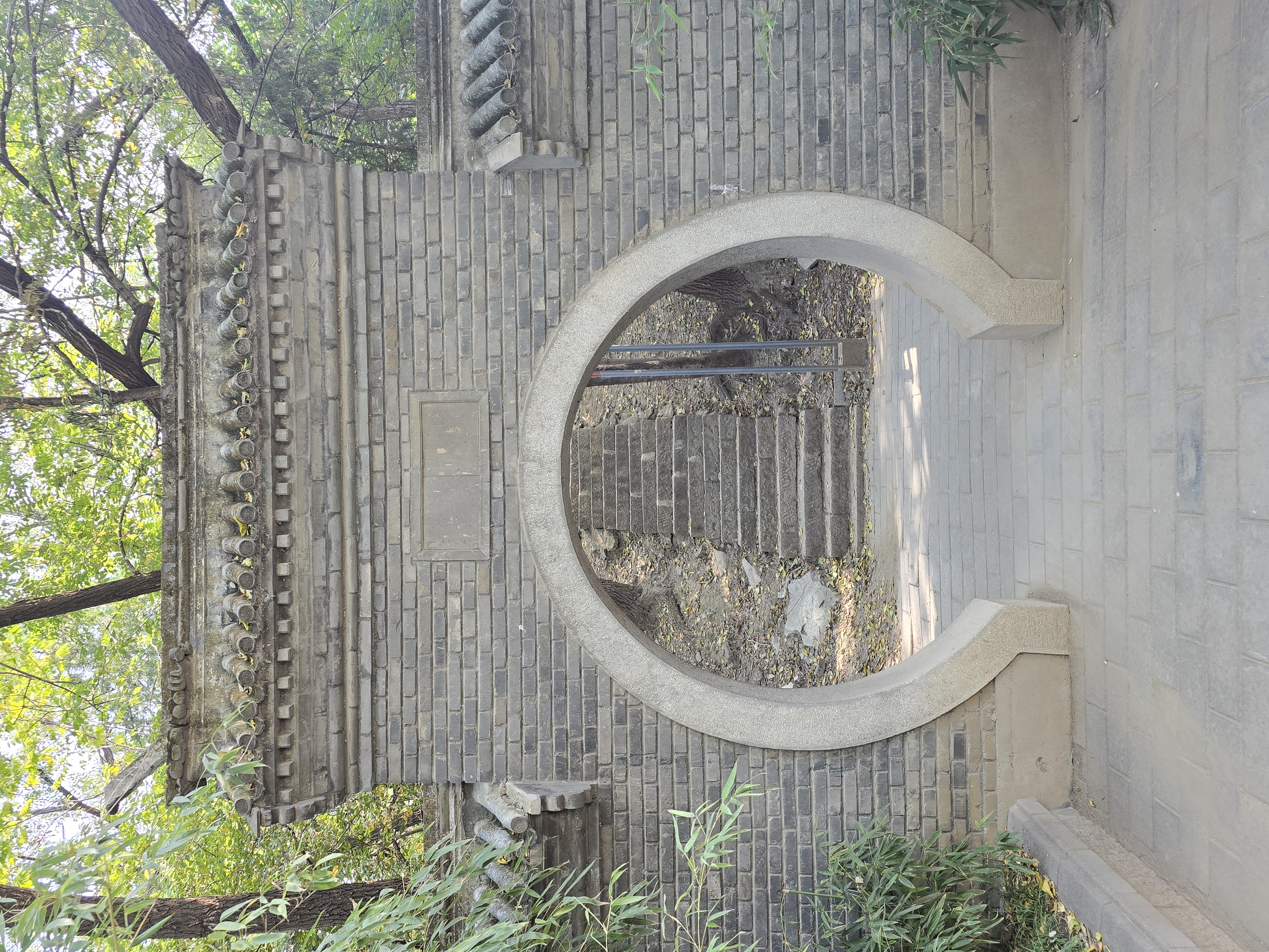 A moon gate frames a narrow stone path.