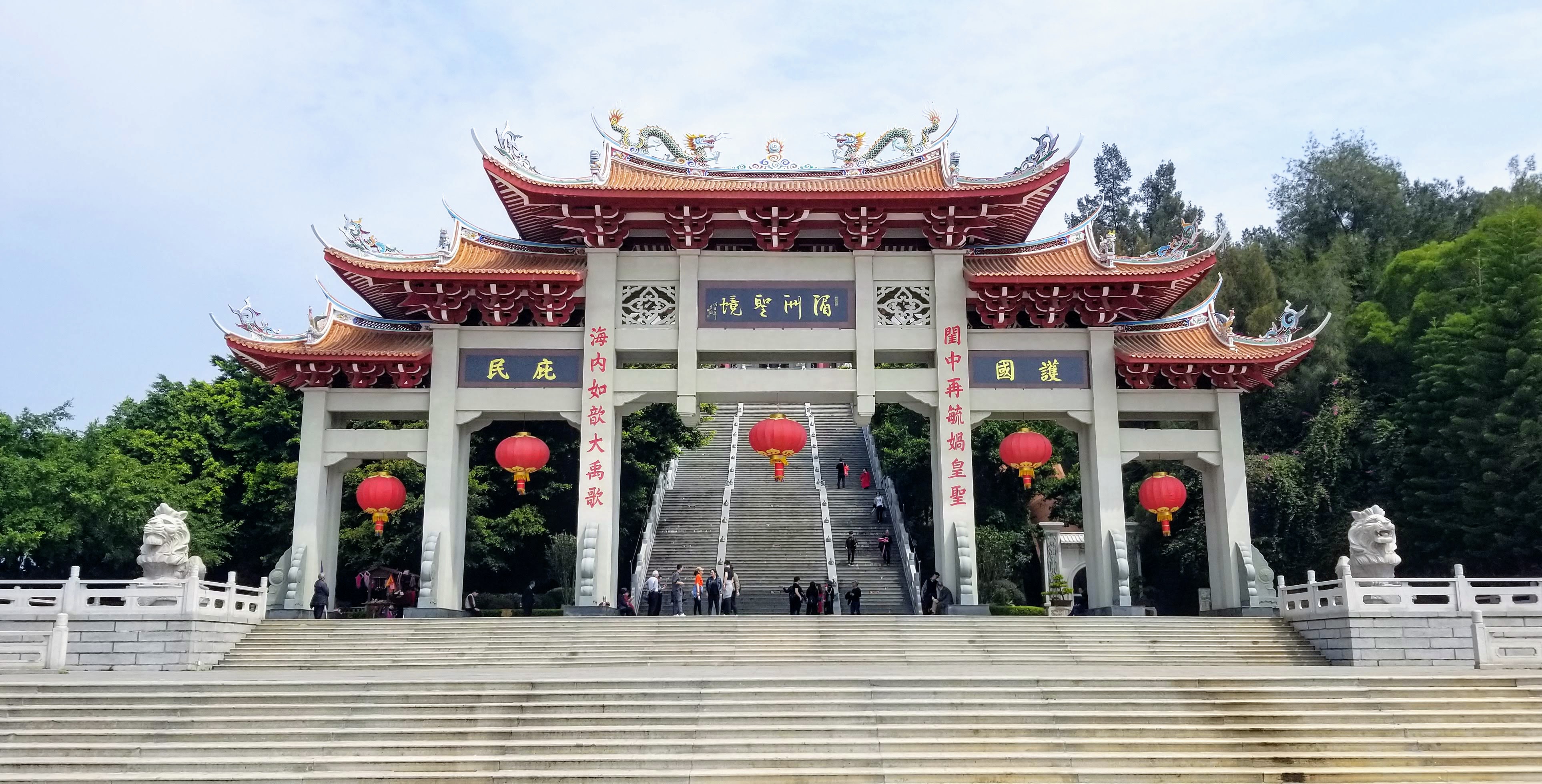 An ornate multi-roofed paifang gate above broad stone steps