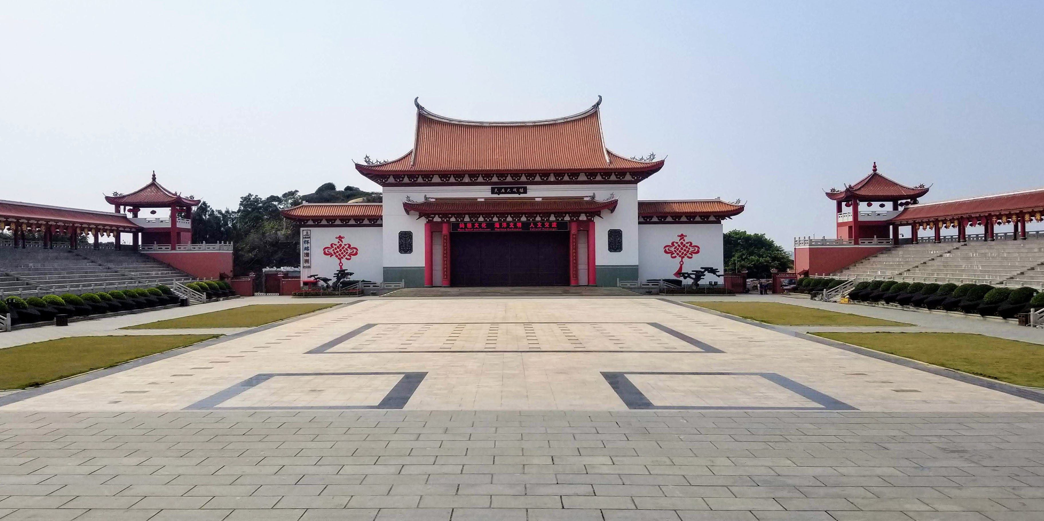 A broad ceremonial courtyard facing a red-roofed stage