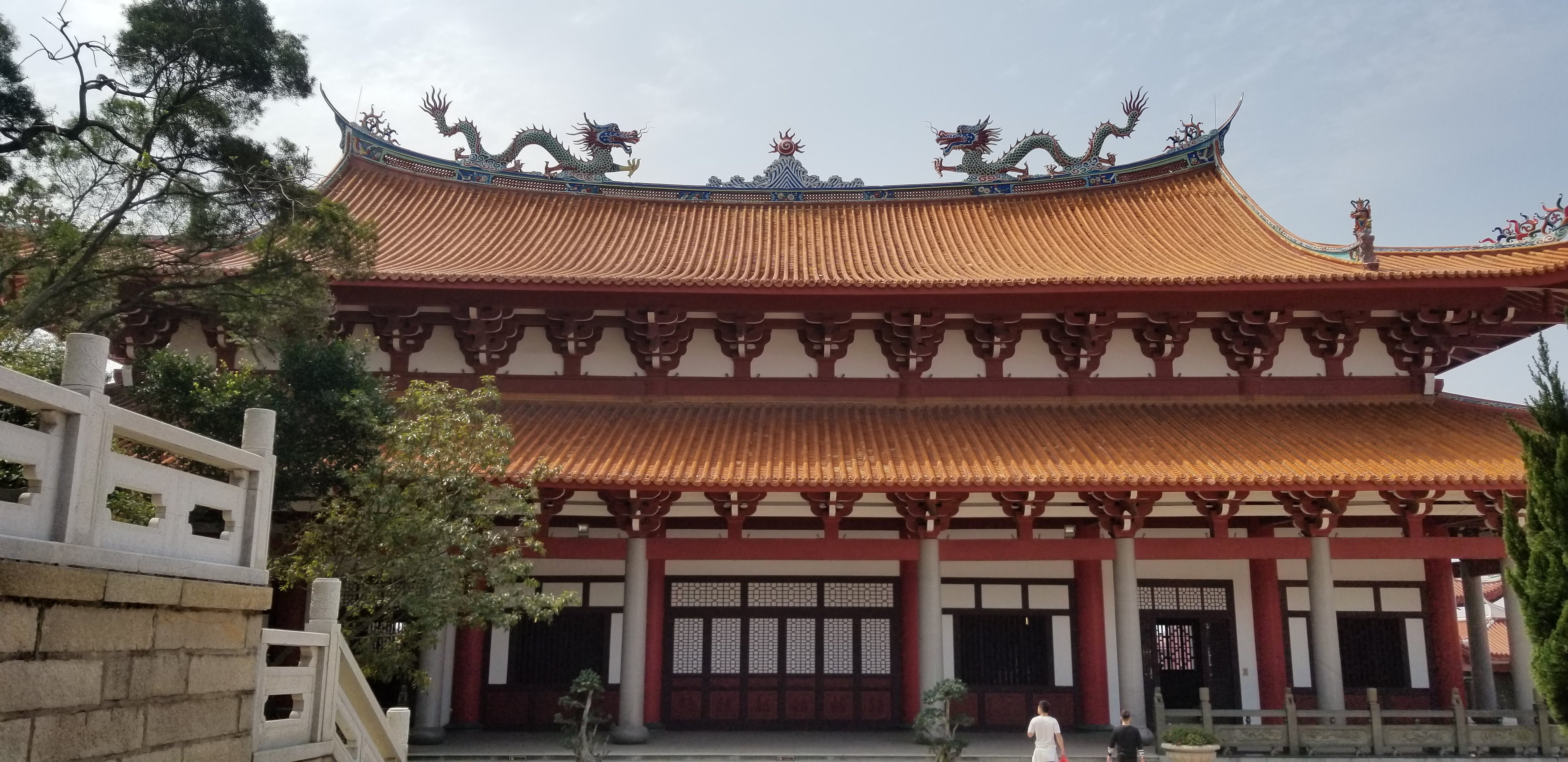 Dragons along an orange temple roof above red columns