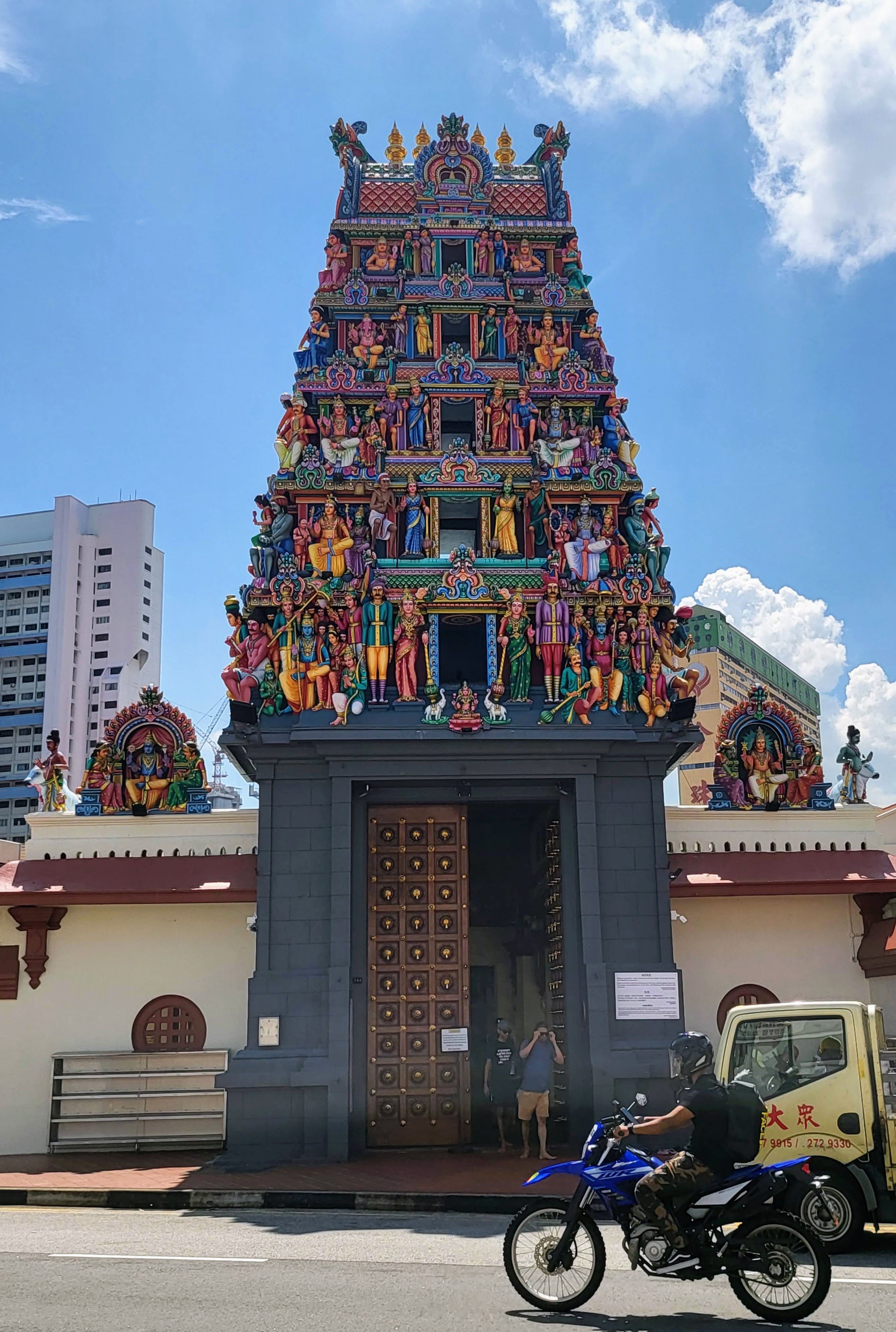 A Hindu temple entrance tower covered in colorful sculpted figures