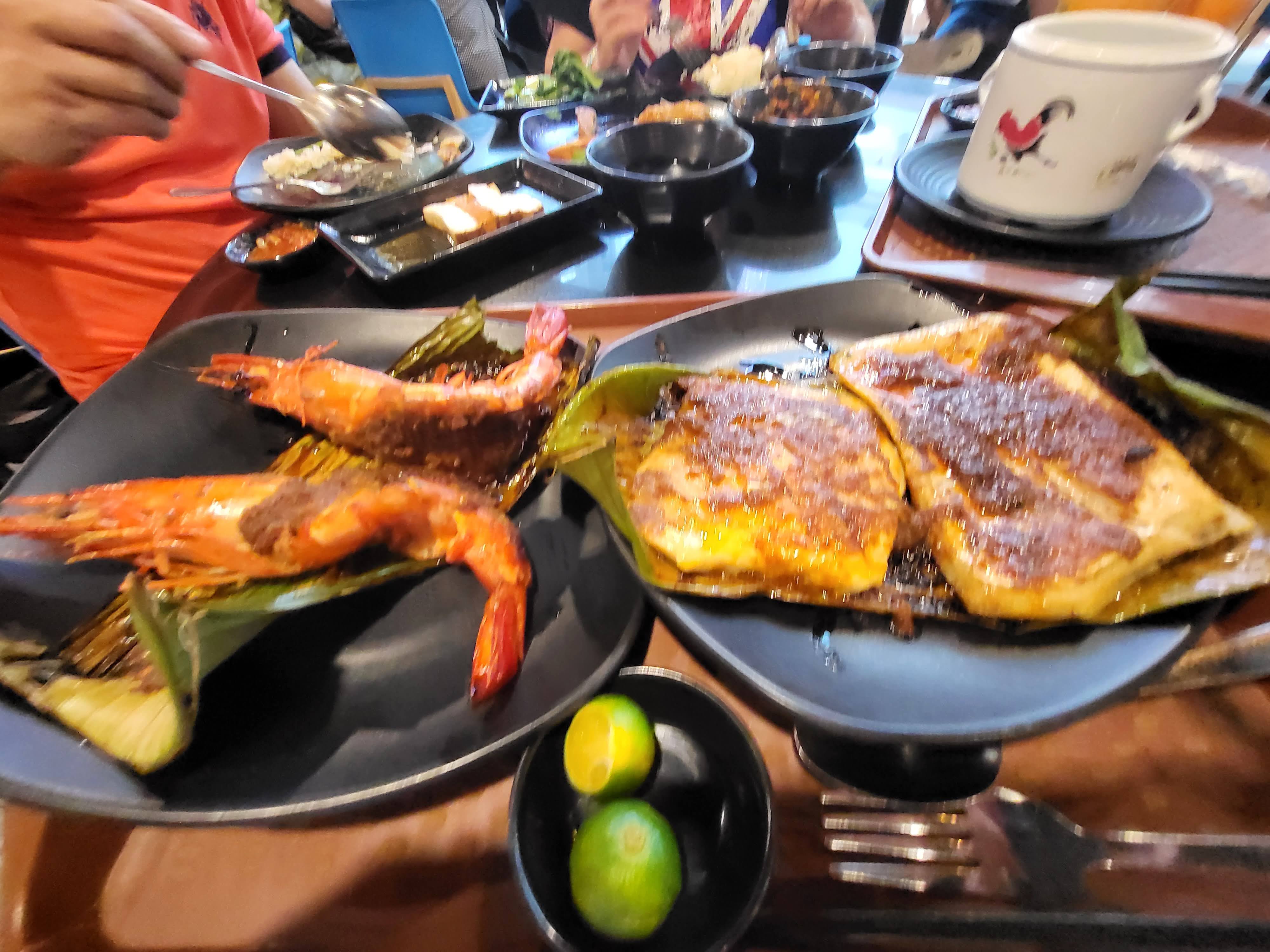 Grilled seafood and side dishes covering a restaurant table