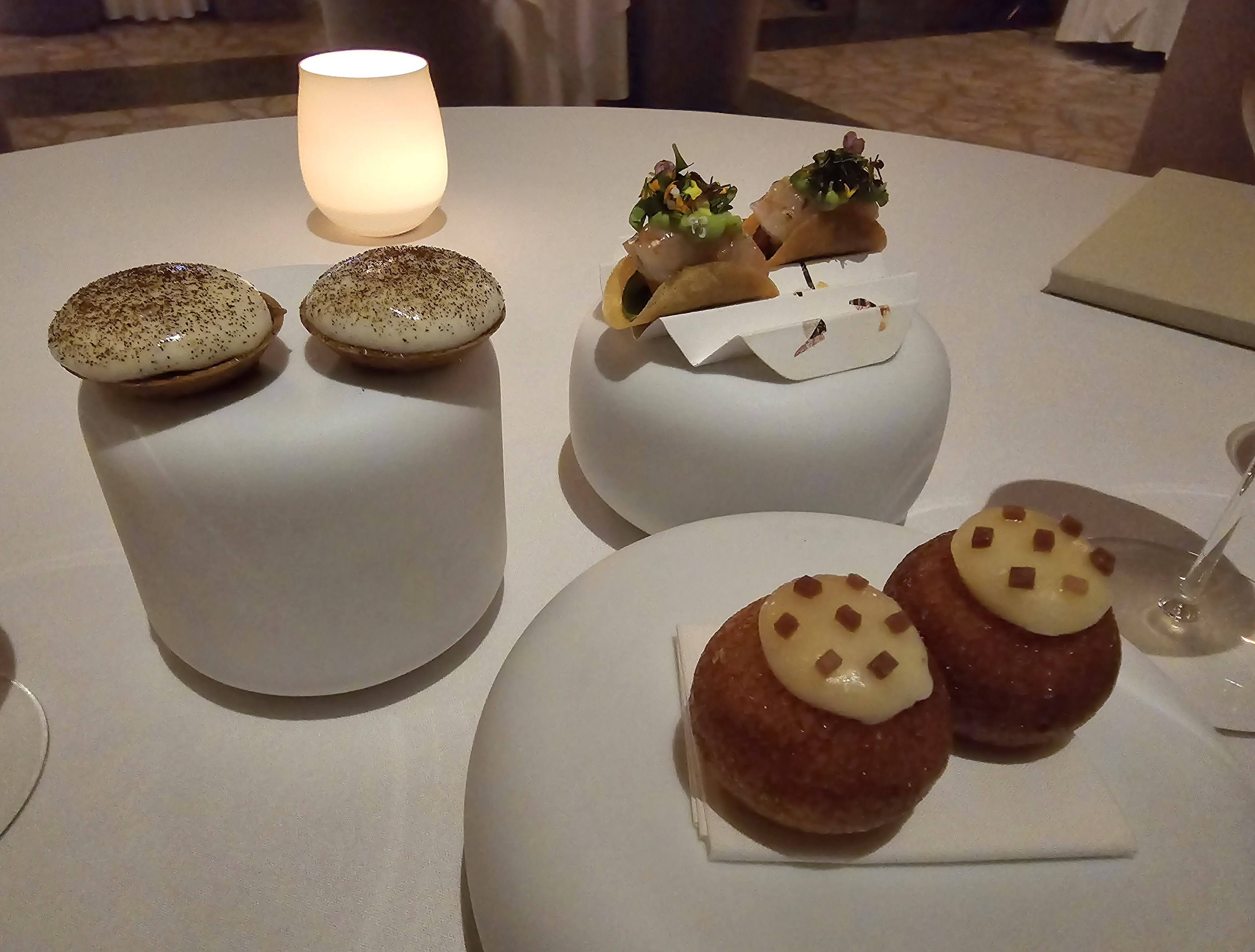 Small plated bites presented at a softly lit restaurant table