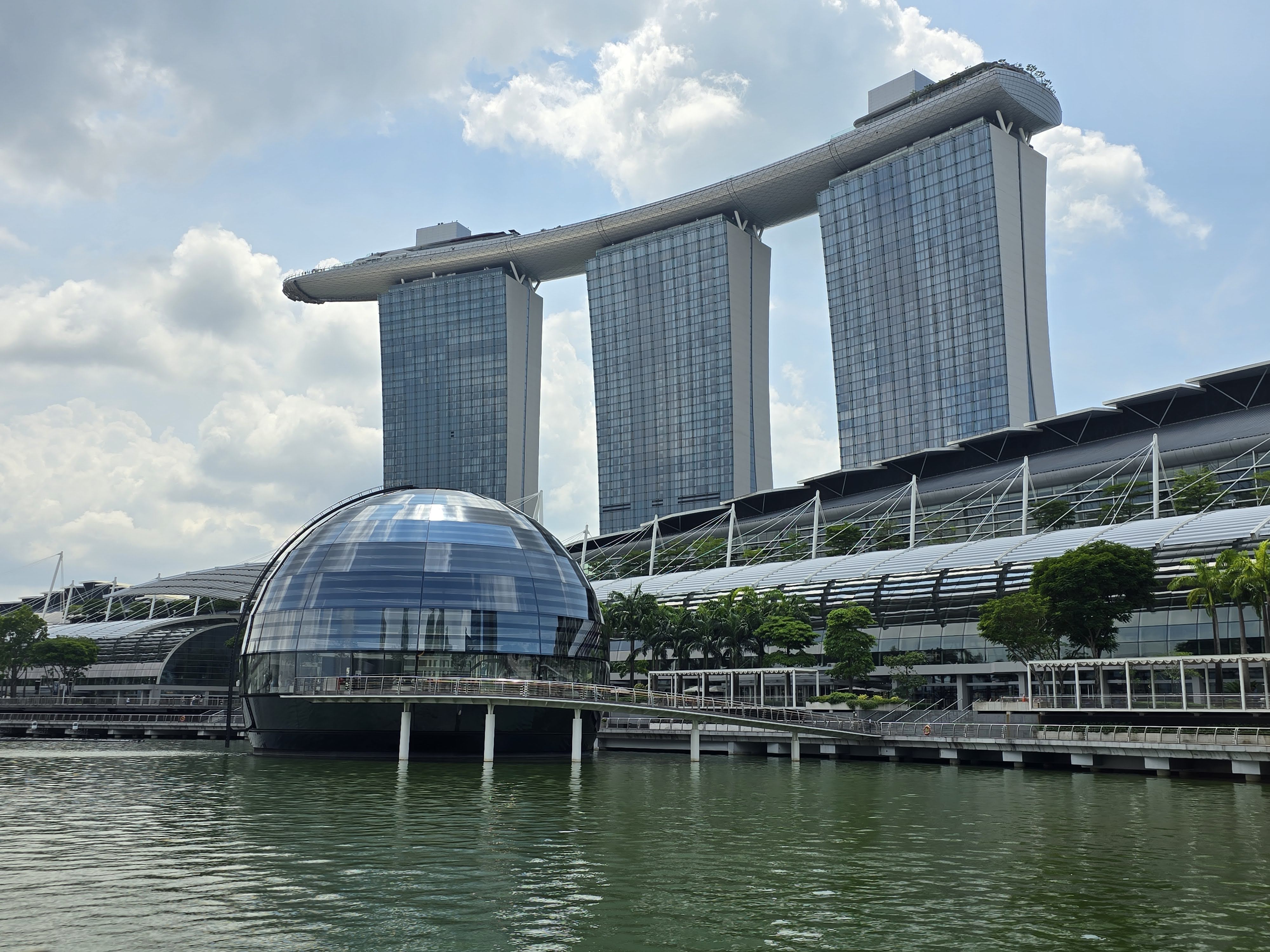 Marina Bay Sands behind a spherical glass pavilion on the waterfront