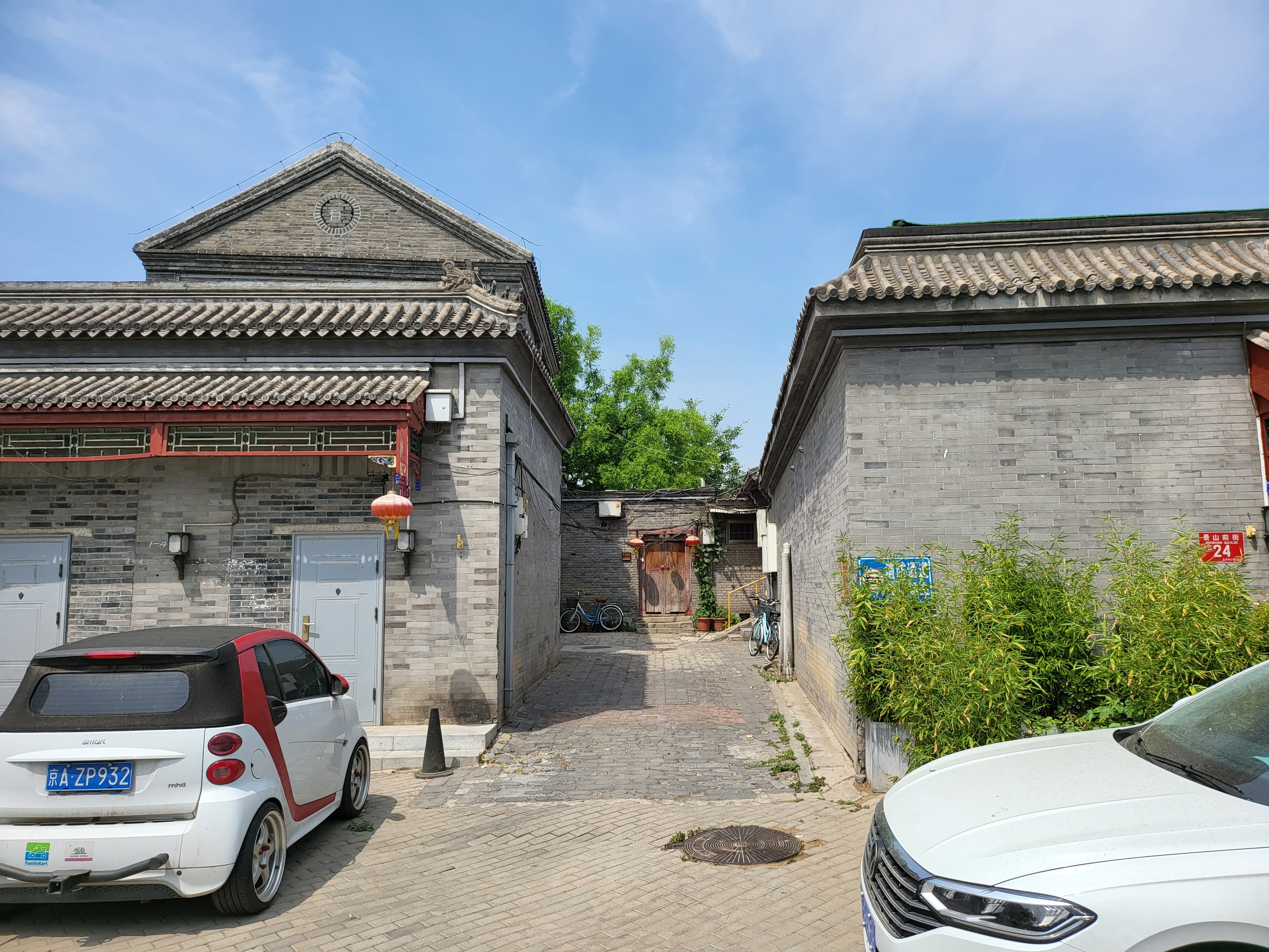 Grey-brick gateways and tiled roofs along a quiet street.