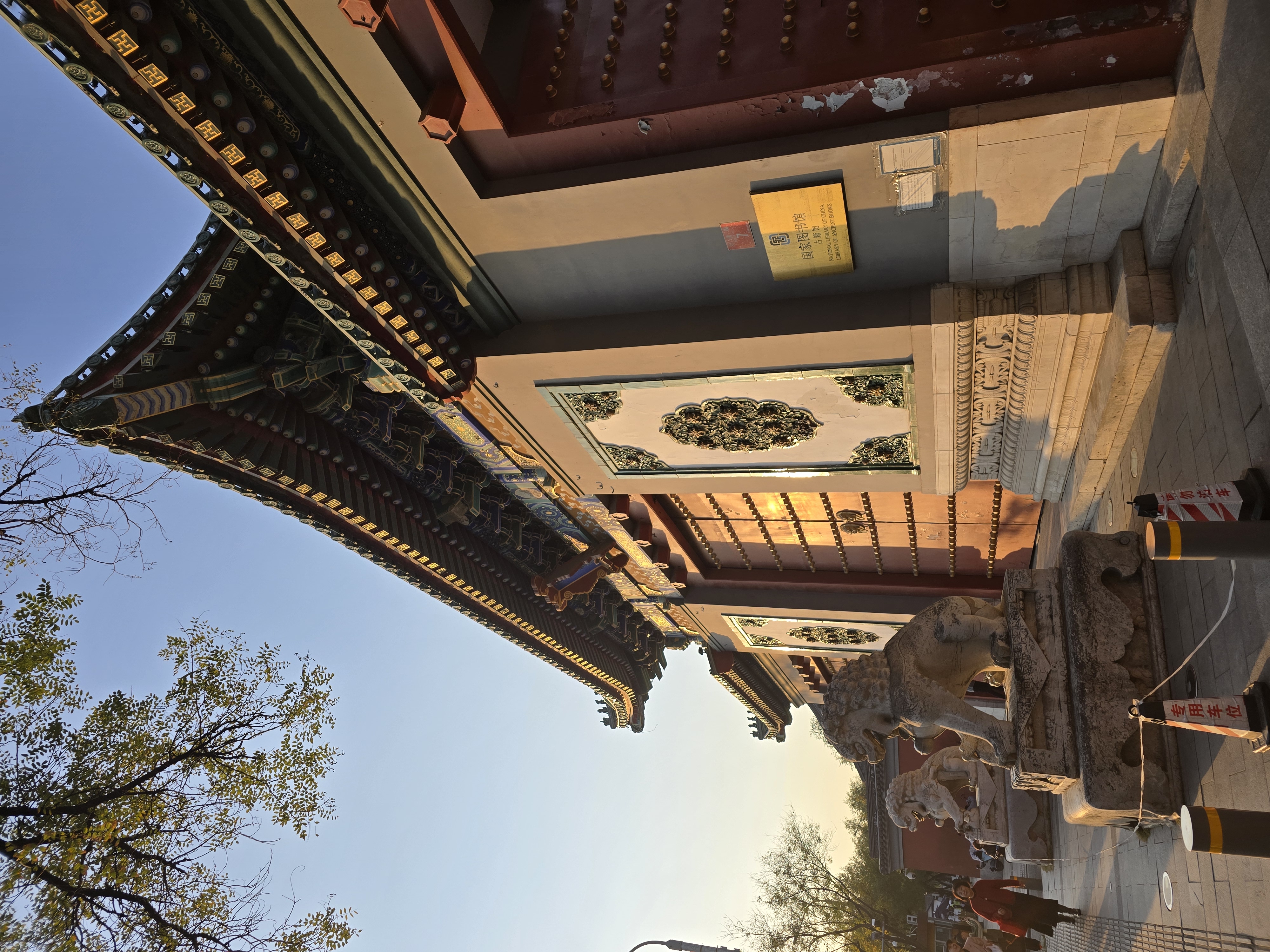 Painted eaves and red doors along a traditional temple wall.